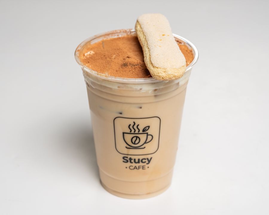 Iced tiramisu latte topped with a ladyfinger